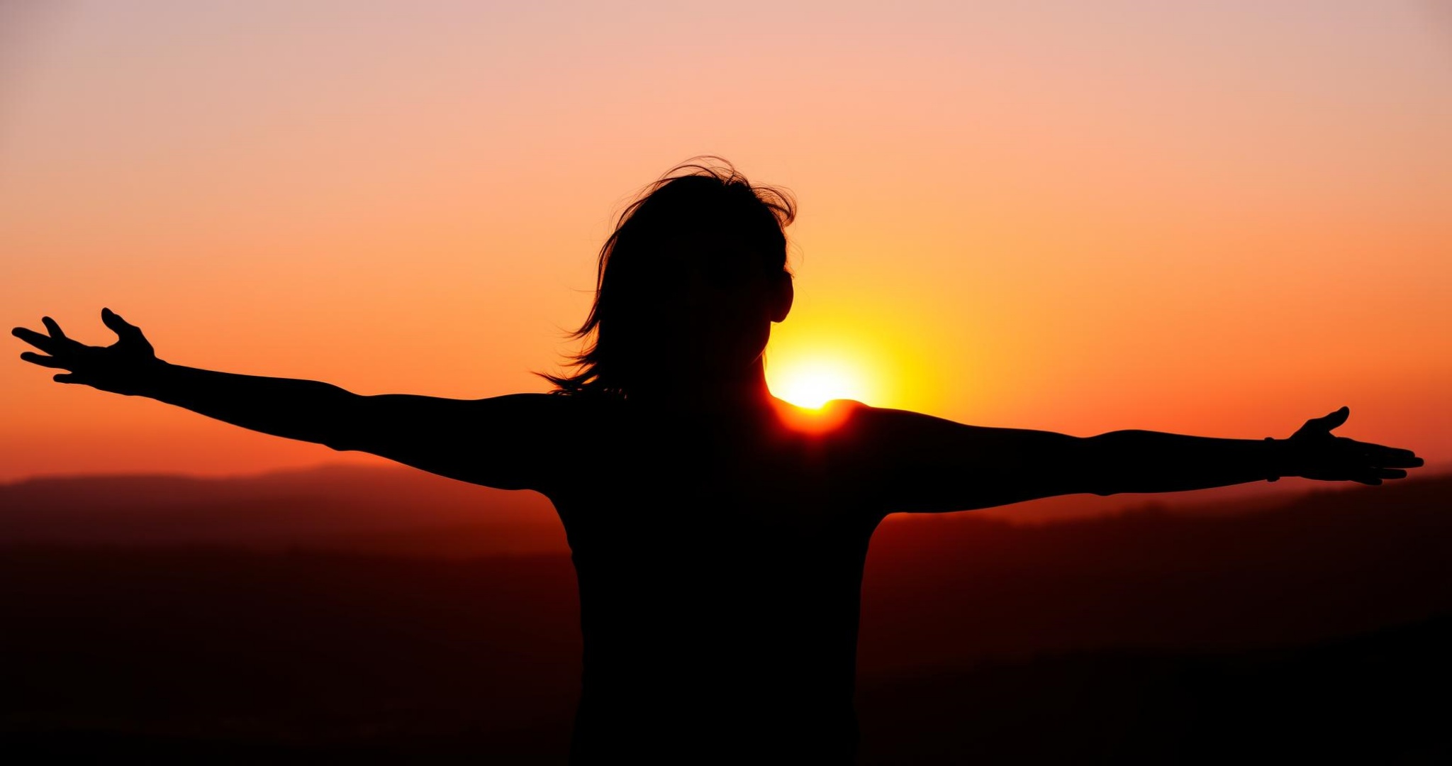 A_dark_silhouette_of_a_woman_with_her_arms_stretched_wide_standing_against_a_vibrant_sunset.